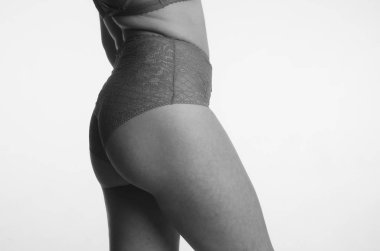 Beyaz arka planda yalnız poz veren dantelli iç çamaşırlı güzel kadın. 