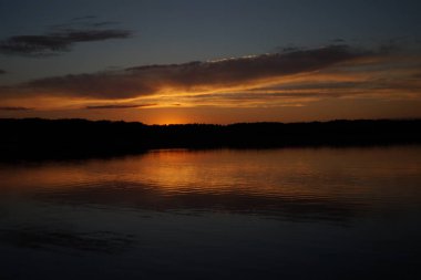 Sabahın erken saatlerinde gölün üzerinde sonsuz karanlık gökyüzü manzarası.   