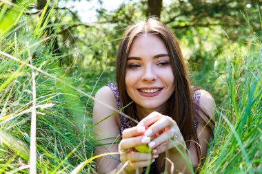 Gölün oradaki tahta iskelede poz veren siyah saçlı kadın. Sırtı Neusiedl Gölü 'nün tahta yaya köprüsüne dönmüş bir kadın. Arka plandaki kayıkhanede güneş yansımaları.