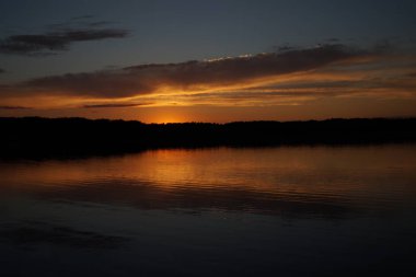Sabahın erken saatlerinde gölün üzerinde sonsuz karanlık gökyüzü manzarası.   