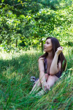 Gölün oradaki tahta iskelede poz veren siyah saçlı kadın. Sırtı Neusiedl Gölü 'nün tahta yaya köprüsüne dönmüş bir kadın. Arka plandaki kayıkhanede güneş yansımaları.