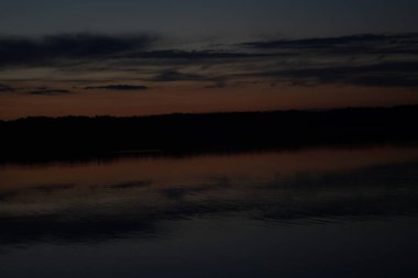 Sabahın erken saatlerinde gölün üzerinde sonsuz karanlık gökyüzü manzarası.   