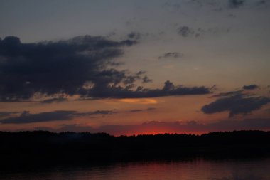 Sabahın erken saatlerinde gölün üzerinde sonsuz karanlık gökyüzü manzarası.   