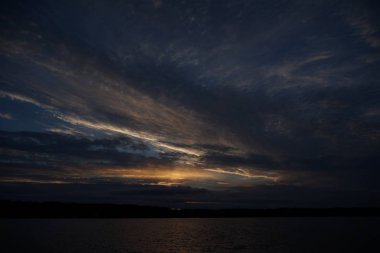 Sabahın erken saatlerinde gölün üzerinde sonsuz karanlık gökyüzü manzarası.   