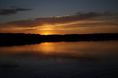 Sabahın erken saatlerinde gölün üzerinde sonsuz karanlık gökyüzü manzarası.   