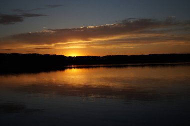 Sabahın erken saatlerinde gölün üzerinde sonsuz karanlık gökyüzü manzarası.   