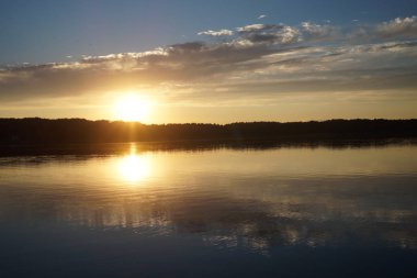 Gün batımının resimsel görüntüsü gölün ayna yüzeyine yansıyor 