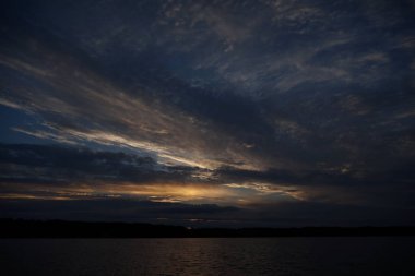 Sabahın erken saatlerinde gölün üzerinde sonsuz karanlık gökyüzü manzarası.   