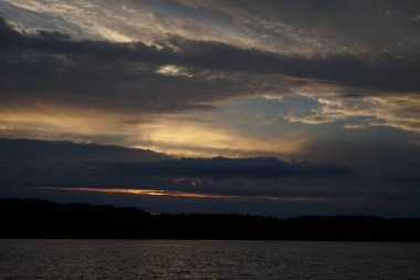 Sabahın erken saatlerinde gölün üzerinde sonsuz karanlık gökyüzü manzarası.   