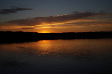 Sabahın erken saatlerinde gölün üzerinde sonsuz karanlık gökyüzü manzarası.   