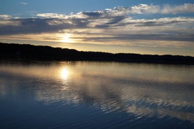 Gün batımının resimsel görüntüsü gölün ayna yüzeyine yansıyor 