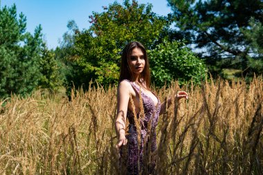 Gölün oradaki tahta iskelede poz veren siyah saçlı kadın. Sırtı Neusiedl Gölü 'nün tahta yaya köprüsüne dönmüş bir kadın. Arka plandaki kayıkhanede güneş yansımaları.