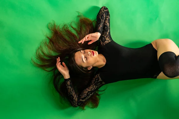 Hermosa chica con estilo de moda en traje de cuerpo en chaquetas de cuero posando en la foto Estudio sobre fondo oscuro con cadenas — Foto de Stock