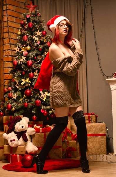 Stüdyoda yeni yıl fotoğraf çekiminde elinde bir kadeh şampanya ve bir şişe ondan olan güzel bir kız. Yeni Yıl Konsepti.