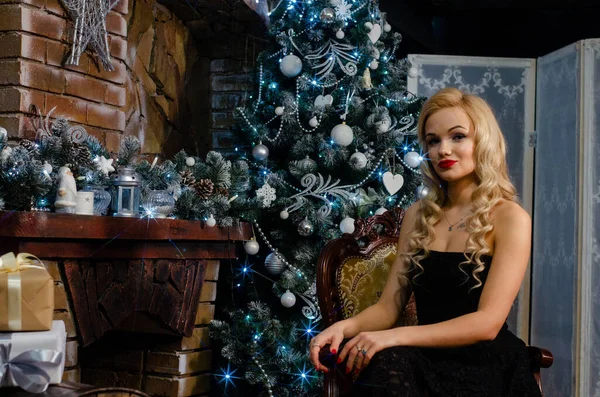 Hermosa silla sentada cerca de la chimenea y del árbol de Navidad, —  Fotos de Stock