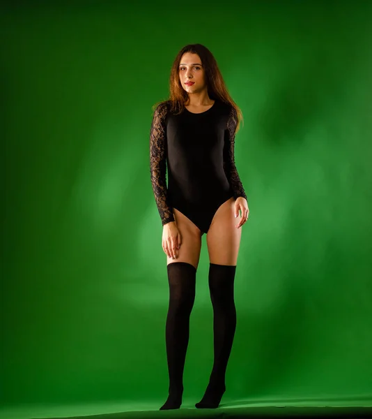 Girl in black bodysuit on green background — Stock Photo, Image