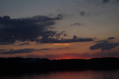 Sabahın erken saatlerinde gölün üzerinde sonsuz karanlık gökyüzü manzarası.   