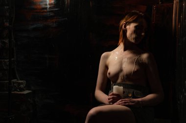 Onun üzerinde yanan bir mum ve balmumu ile iyi şekilli bir kadının vücut günahı