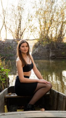 Güz parkındaki güzel genç kız ahşap teknede