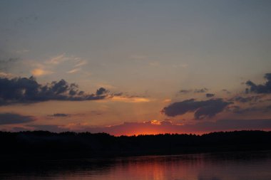 Gün batımının resimsel görüntüsü gölün ayna yüzeyine yansıyor 
