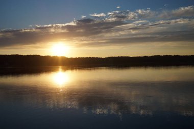 Gün batımının resimsel görüntüsü gölün ayna yüzeyine yansıyor 
