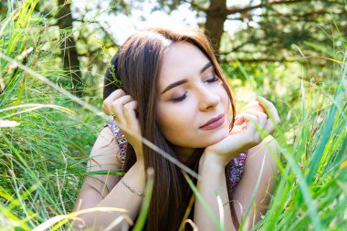 Gölün oradaki tahta iskelede poz veren siyah saçlı kadın. Sırtı Neusiedl Gölü 'nün tahta yaya köprüsüne dönmüş bir kadın. Arka plandaki kayıkhanede güneş yansımaları.