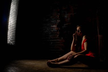 Güzel esmer kadın kırmızı arka planda kırmızı iç çamaşırlarıyla poz veriyor. Stüdyoda kırmızı elbiseli esmer kadın. Formda bir kız. Güzellik, moda ve tarz kavramı. Sevgililer Günü.