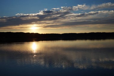 Gün batımının resimsel görüntüsü gölün ayna yüzeyine yansıyor 