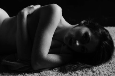 Güzel, çıplak bir kadın karanlık bir odada gizleniyordu. 