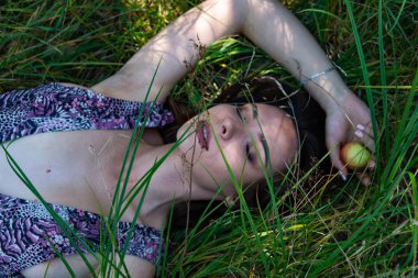 Gölün oradaki tahta iskelede poz veren siyah saçlı kadın. Sırtı Neusiedl Gölü 'nün tahta yaya köprüsüne dönmüş bir kadın. Arka plandaki kayıkhanede güneş yansımaları.