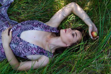 Gölün oradaki tahta iskelede poz veren siyah saçlı kadın. Sırtı Neusiedl Gölü 'nün tahta yaya köprüsüne dönmüş bir kadın. Arka plandaki kayıkhanede güneş yansımaları.