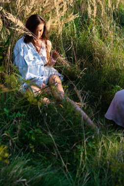 Yeşil çayırlarda poz veren yaz kıyafetleri içinde güzel bir kadın. 