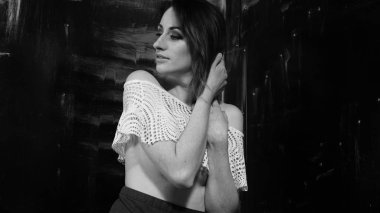 Güzel ıslak büyük göğüslü kız karanlık bir arka plan üzerinde siyah mayo giyiyor. Düşen yağmur damlaları ve sanatsal doğal duman. Reklam, ticari tasarım. Uzay kopyalayın. Karışık Asya-Kafkas yarış.