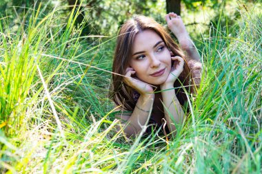 Gölün oradaki tahta iskelede poz veren siyah saçlı kadın. Sırtı Neusiedl Gölü 'nün tahta yaya köprüsüne dönmüş bir kadın. Arka plandaki kayıkhanede güneş yansımaları.