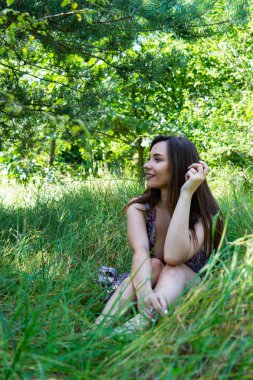 Gölün oradaki tahta iskelede poz veren siyah saçlı kadın. Sırtı Neusiedl Gölü 'nün tahta yaya köprüsüne dönmüş bir kadın. Arka plandaki kayıkhanede güneş yansımaları.