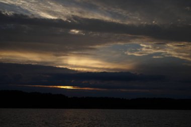 Sabahın erken saatlerinde gölün üzerinde sonsuz karanlık gökyüzü manzarası.   