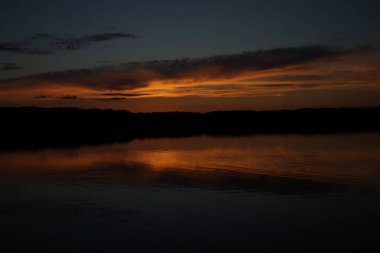 Sabahın erken saatlerinde gölün üzerinde sonsuz karanlık gökyüzü manzarası.   