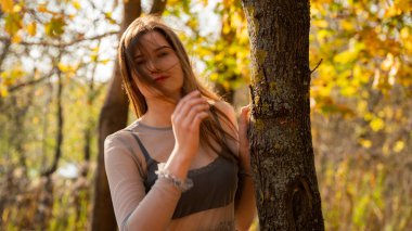 Sonbaharda parkta yürüyen genç ve güzel bir kadın.