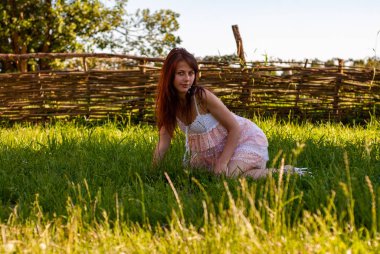 Kırsal kesimde kameraya poz veren çekici genç bir kadın.