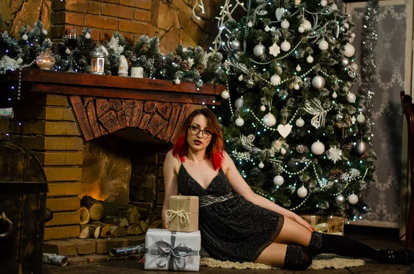 Ein junges schönes Mädchen mit einem Glas Champagner und einer Flasche von ihr beim Neujahrs-Fotoshooting im Studio. das Neujahrskonzept. — Stockfoto
