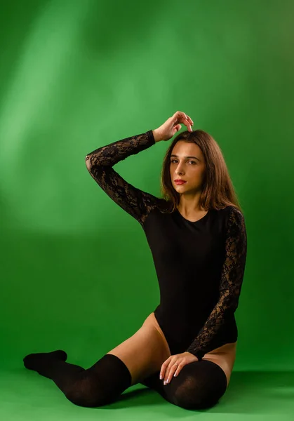 Chica en traje negro sobre fondo verde —  Fotos de Stock