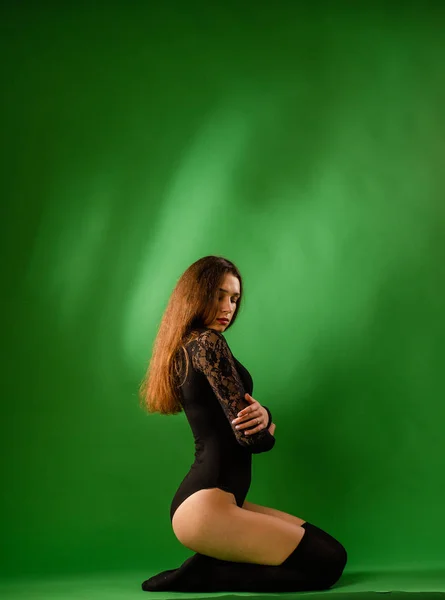 Κορίτσι σε μαύρο bodysuit σε πράσινο φόντο — Φωτογραφία Αρχείου