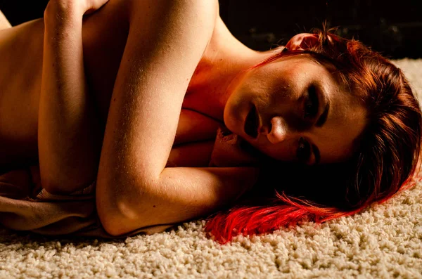Nude with punk hair curled up on the floor — Stock Photo, Image