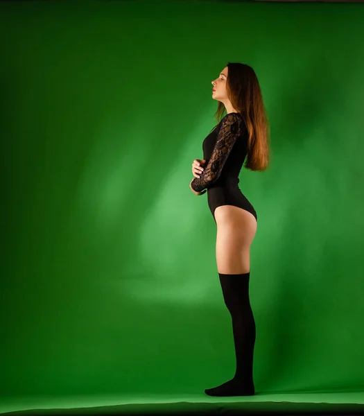 Girl in black bodysuit on green background — Stock Photo, Image