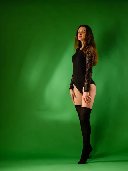 Girl in black bodysuit on green background — Stock Photo, Image