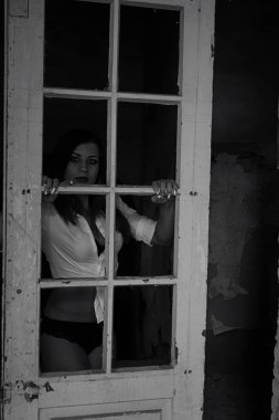 Eski binada iç çamaşırlı seksi esmer kadın poz veriyor.