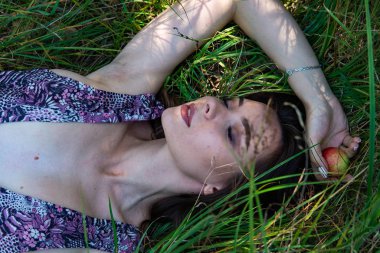 Gölün oradaki tahta iskelede poz veren siyah saçlı kadın. Sırtı Neusiedl Gölü 'nün tahta yaya köprüsüne dönmüş bir kadın. Arka plandaki kayıkhanede güneş yansımaları.