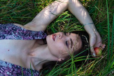 Gölün oradaki tahta iskelede poz veren siyah saçlı kadın. Sırtı Neusiedl Gölü 'nün tahta yaya köprüsüne dönmüş bir kadın. Arka plandaki kayıkhanede güneş yansımaları.