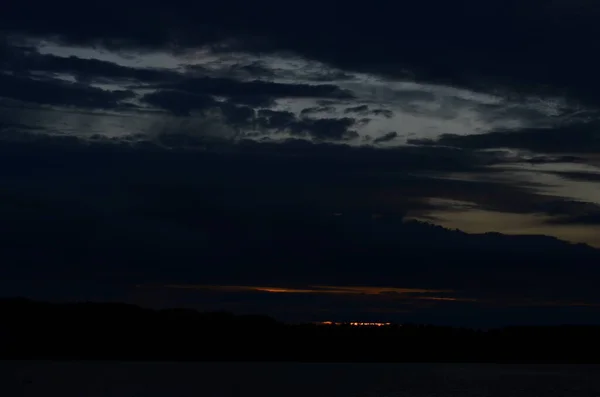 Nuages de tempête sur une plage du lac au coucher du soleil — Photo