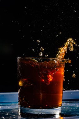 Parçalanmış bir camın kırılması. Siyah zemin üzerinde renkli bir sıvıyla bir camın patlaması. Renk lekeleri